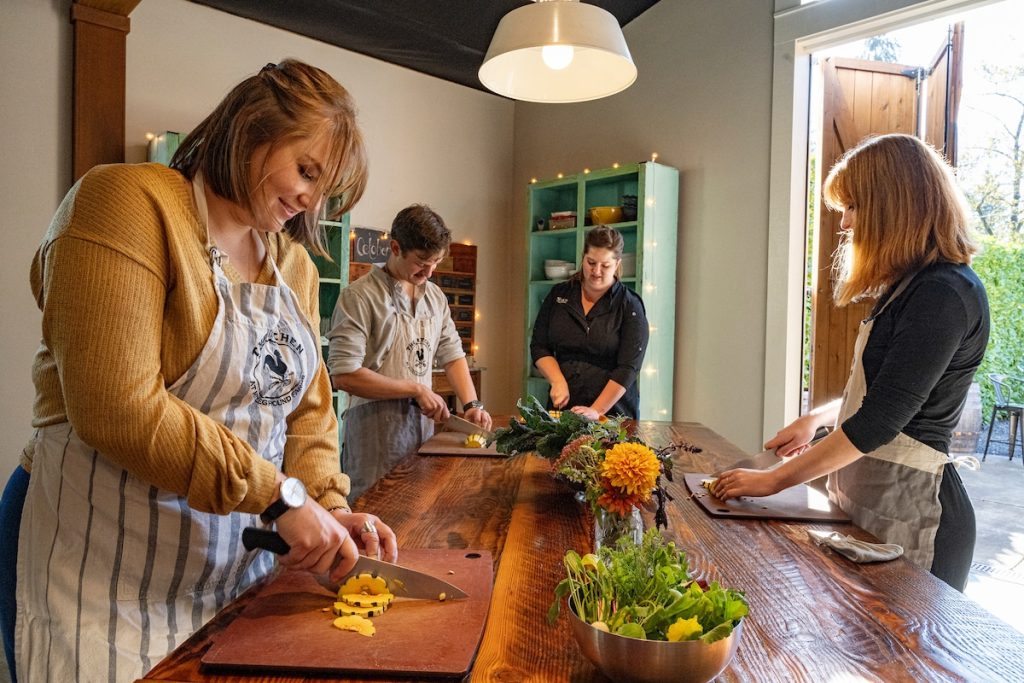 Three people participating in a cooking class at The Kitchen at Middleground Farms