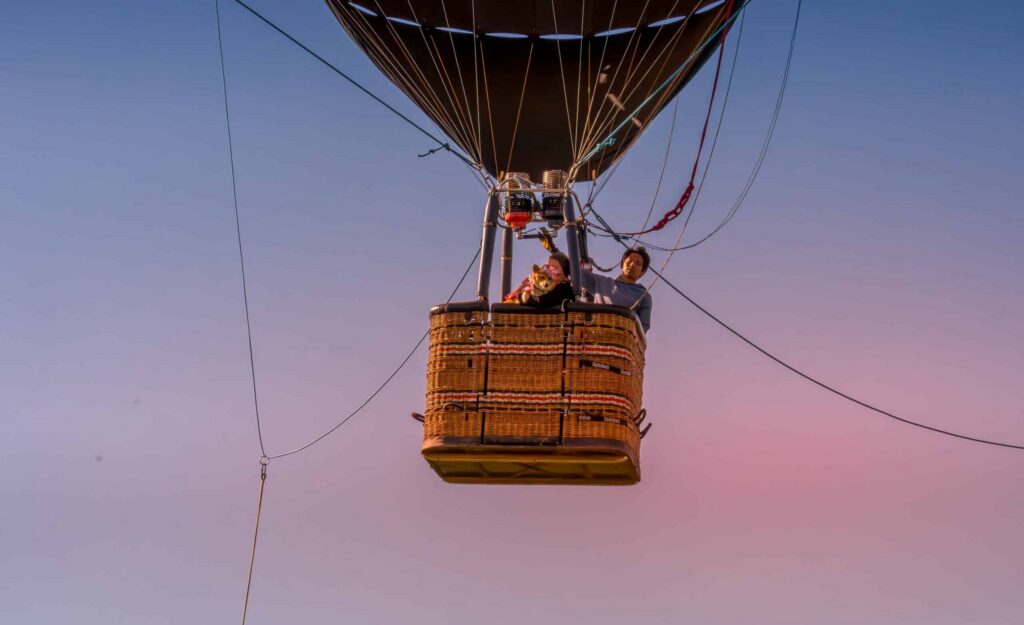 Photo of a hot air balloon basket in the air with two people inside taken near Wilsonville, OR