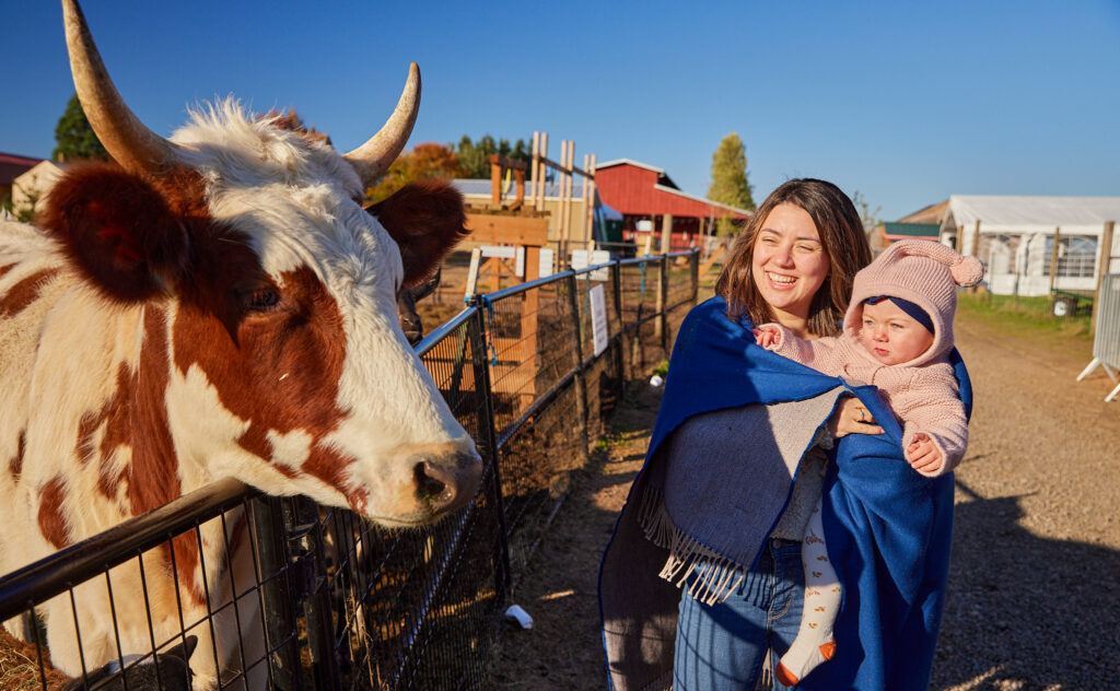 10 Things To Do Under $10 itinerary cover photo showing a mother and young daughter looking at a cow at Frog Pond Farm in Wilsonville, Oregon