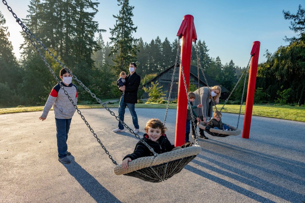A family playing on swings at a park
