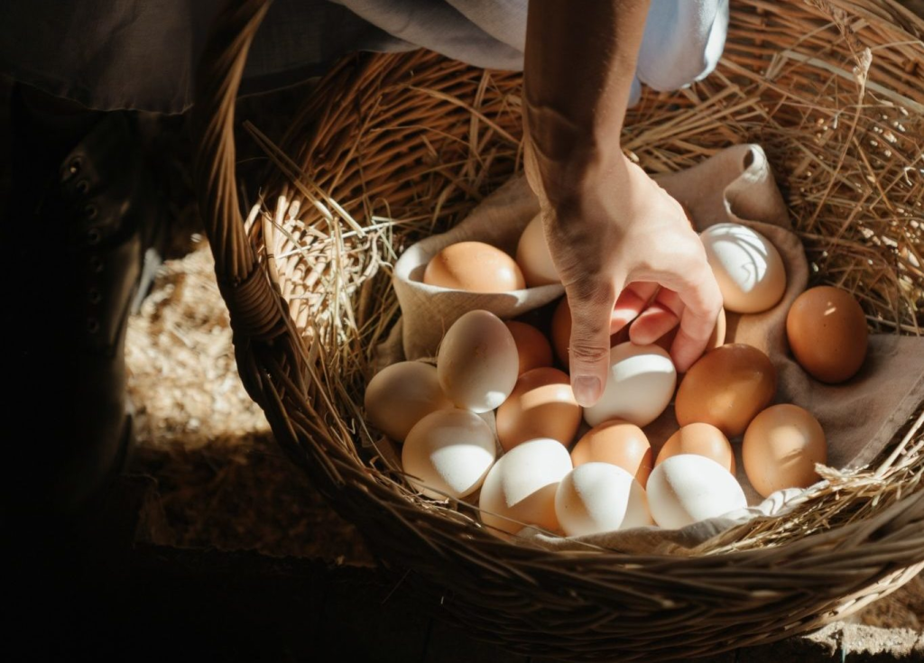 Man picking an egg out of a basket
