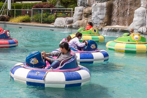 People and children riding on bumper boats at Bullwinkle's