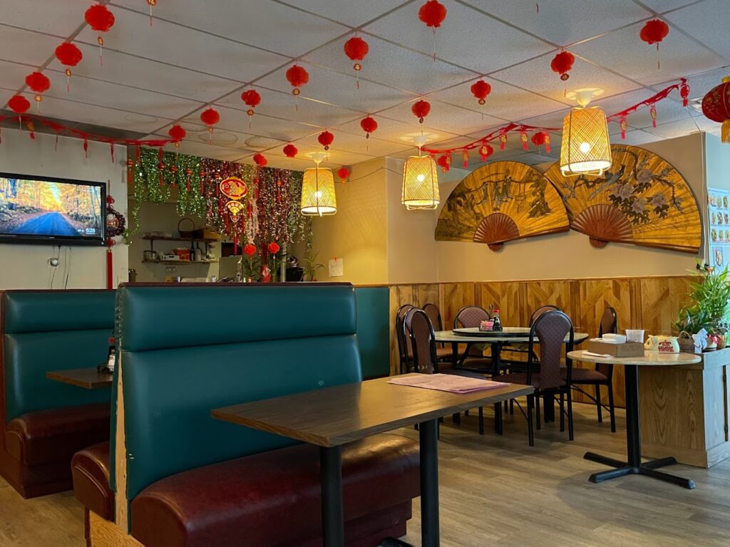 New Hunan Kitchen's entrance with hanging lanterns, blue booths and chairs and tables.