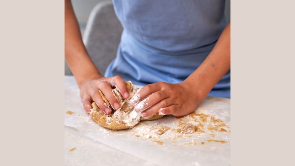 photo of a person working dough with their hands