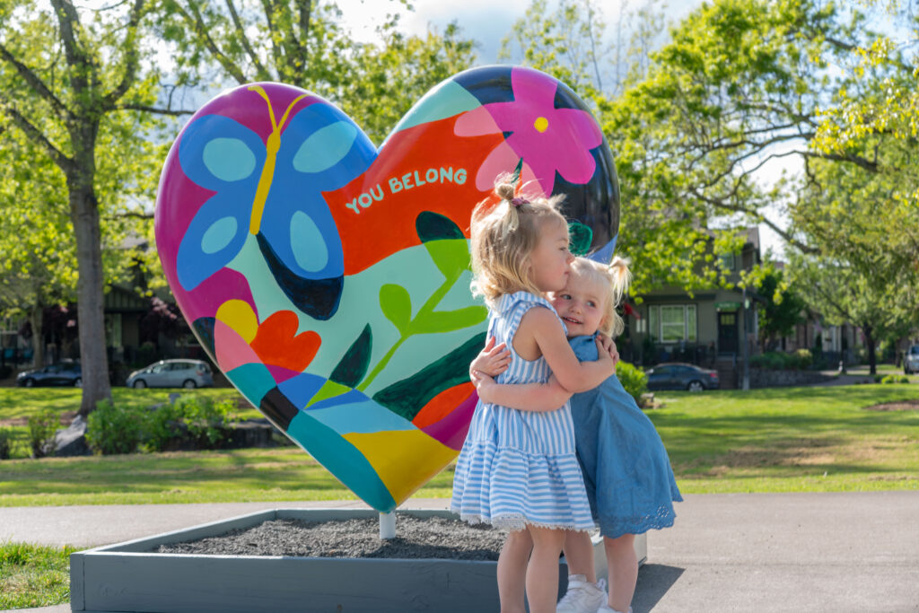 Two young children hugging in front of Hearts of Wilsonville