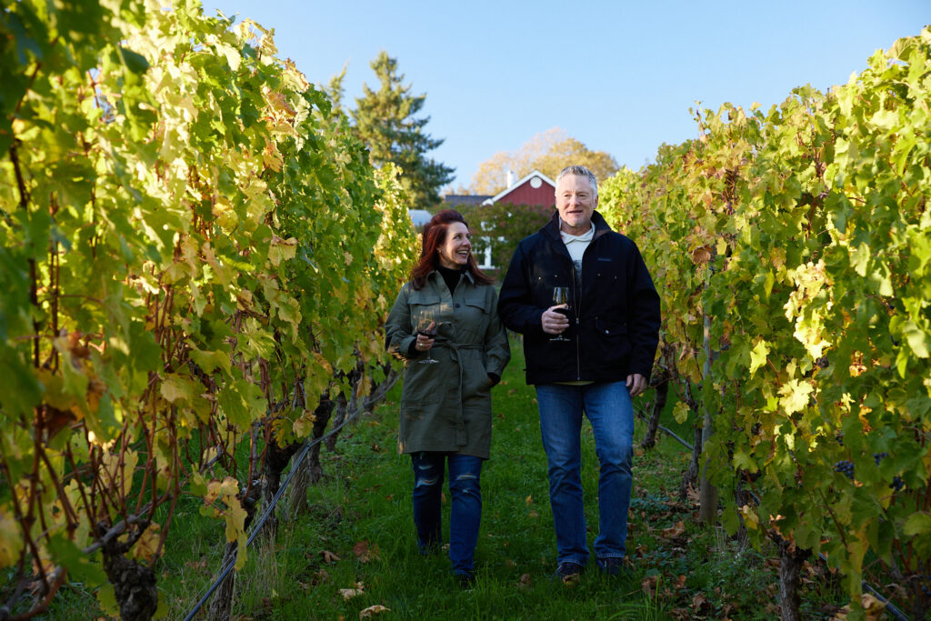 Photo of two people walking through the Terra Vina vineyard in Wilsonville, Oregon
