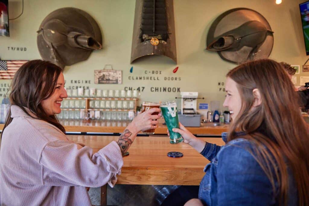 Photo of two women cheersing at Vanguard Brewing in Wilsonville, OR