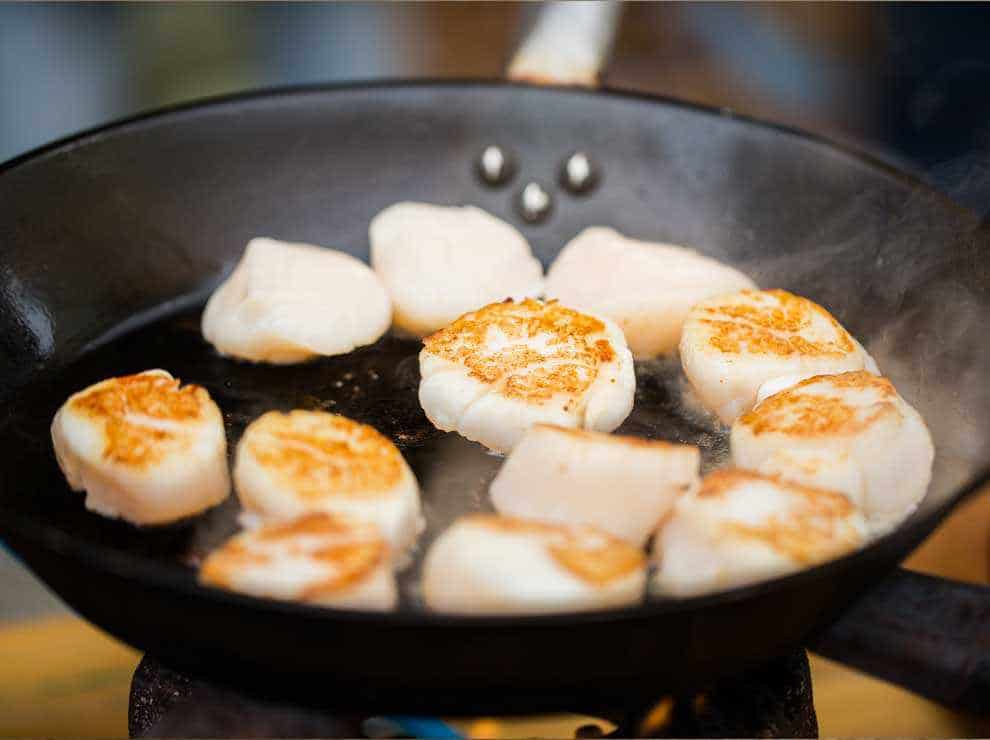 Photo of fish scallops being cooked in a pan
