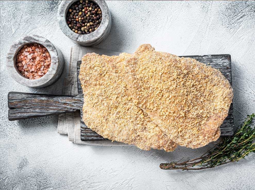photo of chicken cutlets that are ready to be fried