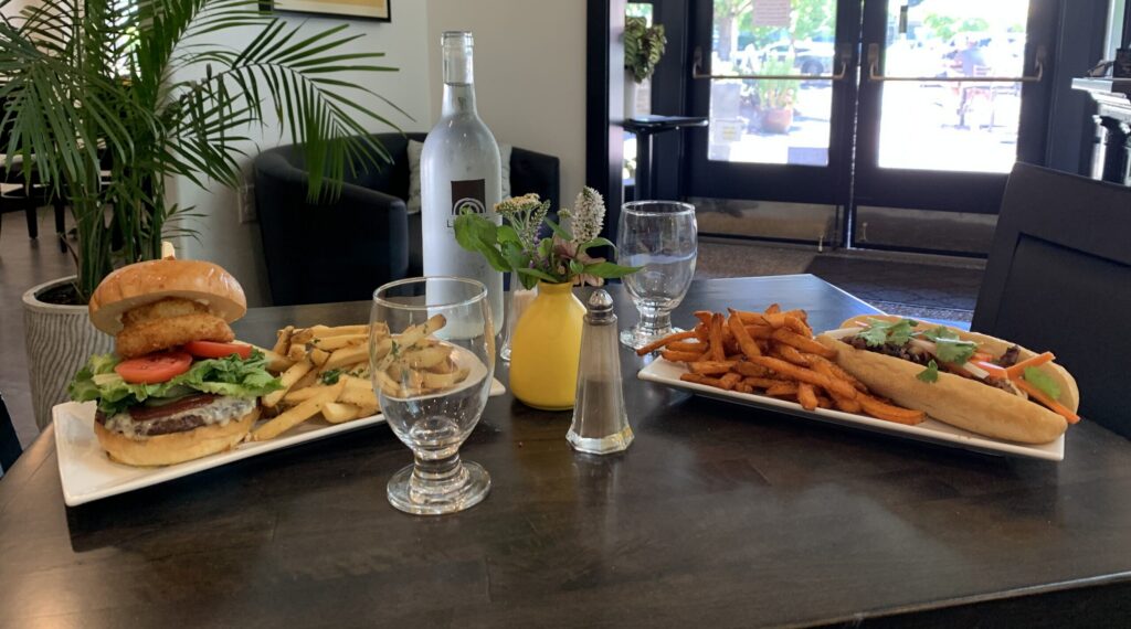 Photo of a bbq burger and bahn mi sandwich on a table at Lumière in Wilsonville, Oregon