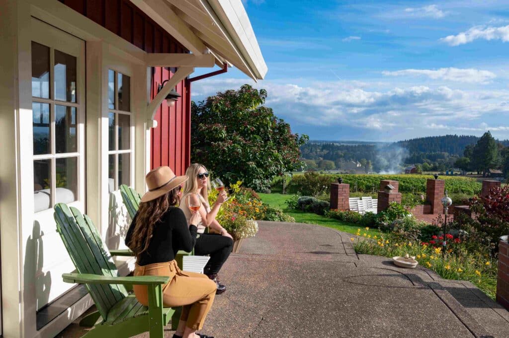 Photo of two people enjoying wine and conversation on the patio at Terra Vina Vineyards near Wilsonville, OR
