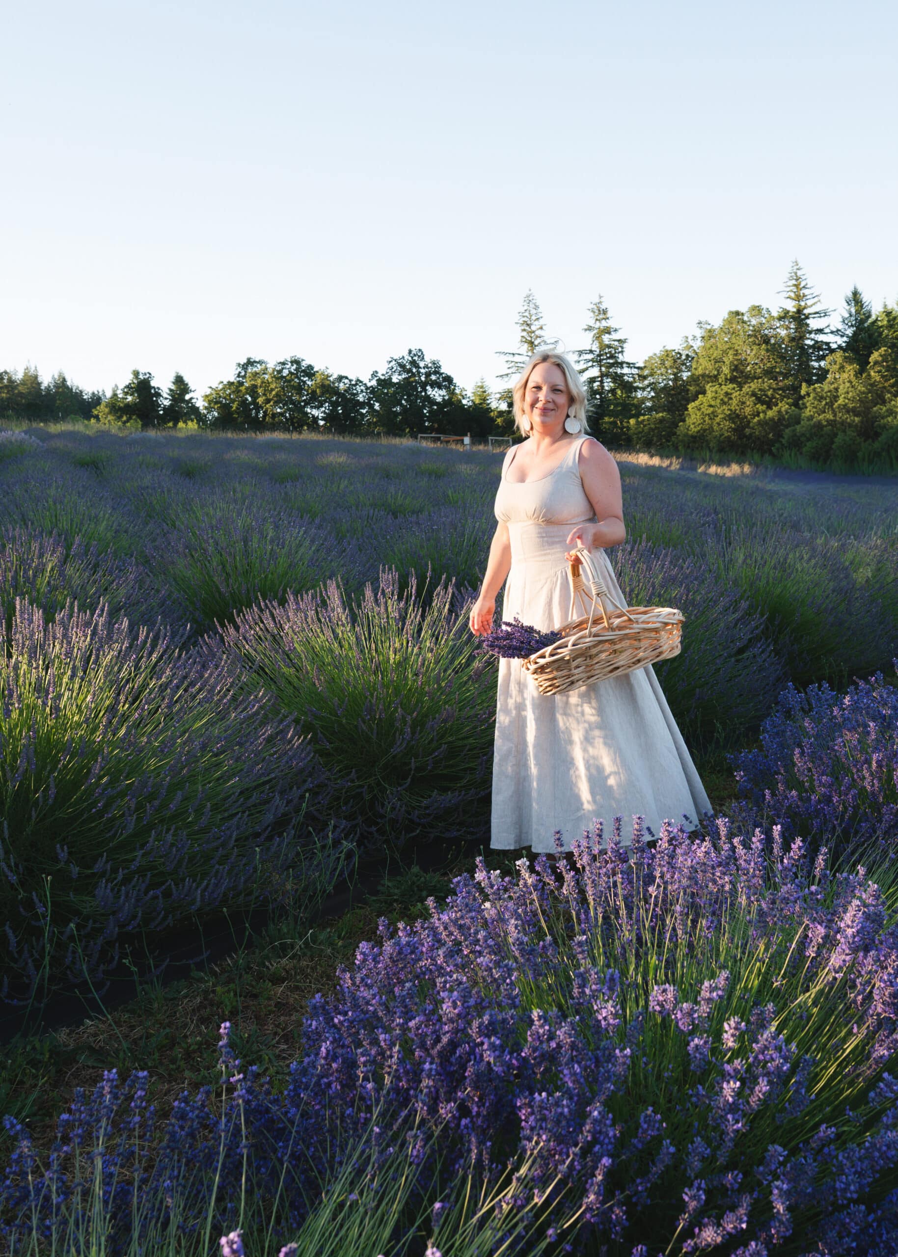 photo of a woman in a lavender field carrying a basket of lavender | Meet the People Behind Three of Wilsonville's Summer Gems