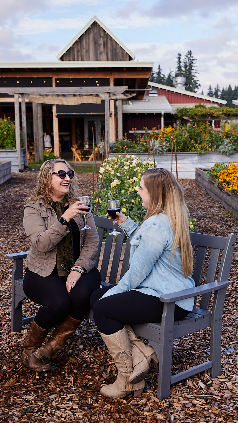 Two women toasting their glasses of wine outside at Our Table Cooperative farm | Accessible Travel Fall Wilsonville Oregon